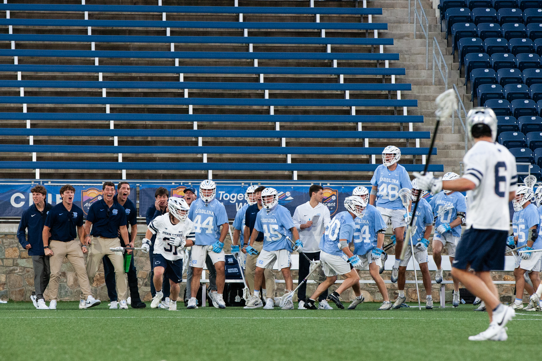 photo of UNC Men's Lacrosse team bench reacting in game against Penn.